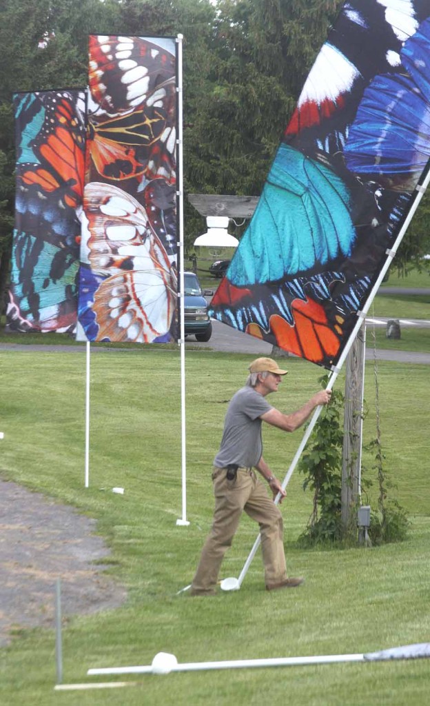 Boulder, Colo., artist George Peters installs one of 12 banners he and fellow artist Melanie Walker devised as a counterbalance to the "Madame Butterfly" tragedy.  (Jim Kevlin/allotsego.com)