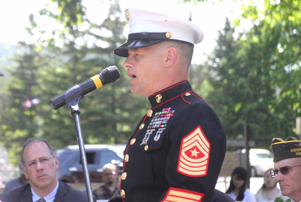Marine Master Sgt. (ret.) Jim Peterson, Fly Creek, whose distiguished career included service in Operation Desert Storm and culminated in the humanitarian effort that followed Cyclone Nargis in Myanmar in 2008, delivers the address at this morning's Memorial Day commemoration at the Soldiers & Sailors' Monument at Main and Pine Boulevard in Coopertown.  Behind him are, left, Mayor Jeff Katz and the VFW's Alan Christman.  (Jim Kevlin/allotsego.com)