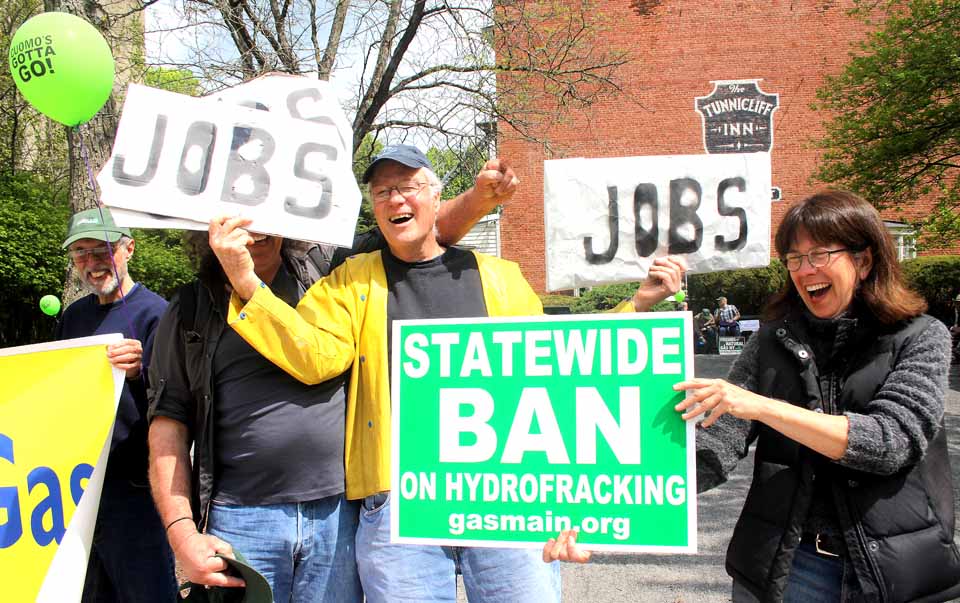 The pro-fracking and anti-fracking movements are well-represented and well-placarded, but -- with the excitement -- not all is serious.  Here, Dick Downey, center, of the Unatego Area Landowners Association, uses his "Jobs" sign to block anti-fracking Bob Eklund, New Lisbon, from the photo.  Not to be outdone, Suzy Winkler, Burlington, parried with her "Statewide Ban" poster.