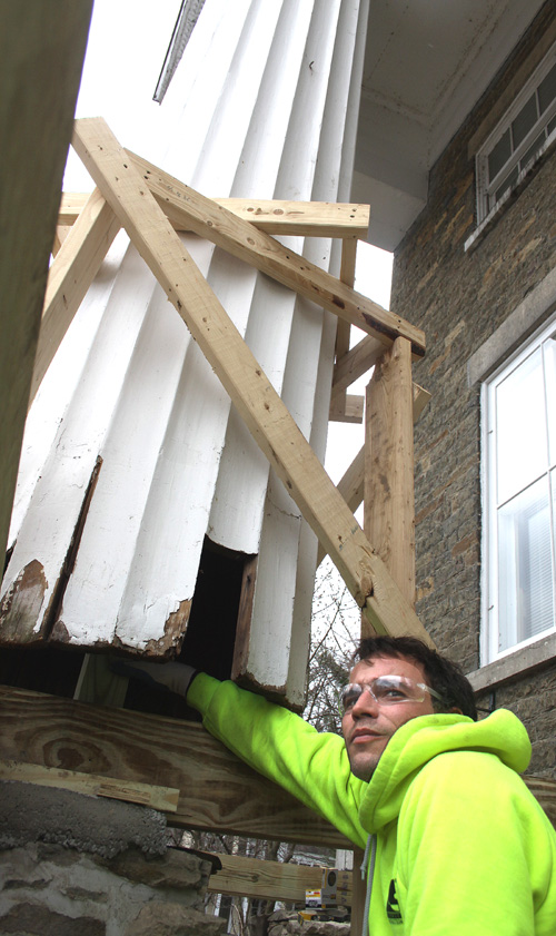 Matt Moore of Roseboom, who works for LeChase Construction, Norwich, pauses from repairs to the four pillars in front of The Leatherstockiing Corp., 19 Main St.