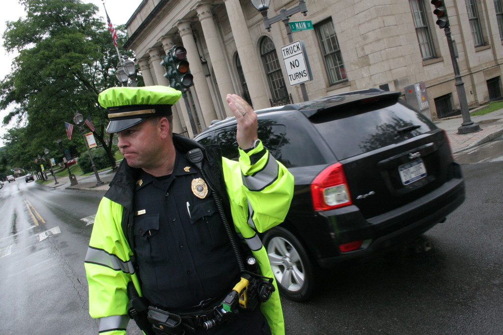 Sgt. Chris Witzenburg directs traffic on the corner of Main St.and Ford Ave. on Monday afternoon after a brief but powerful storm blew through the Oneonta area knocking out power from Tino's Pizzeria to City Hall and down South Main to Market St.