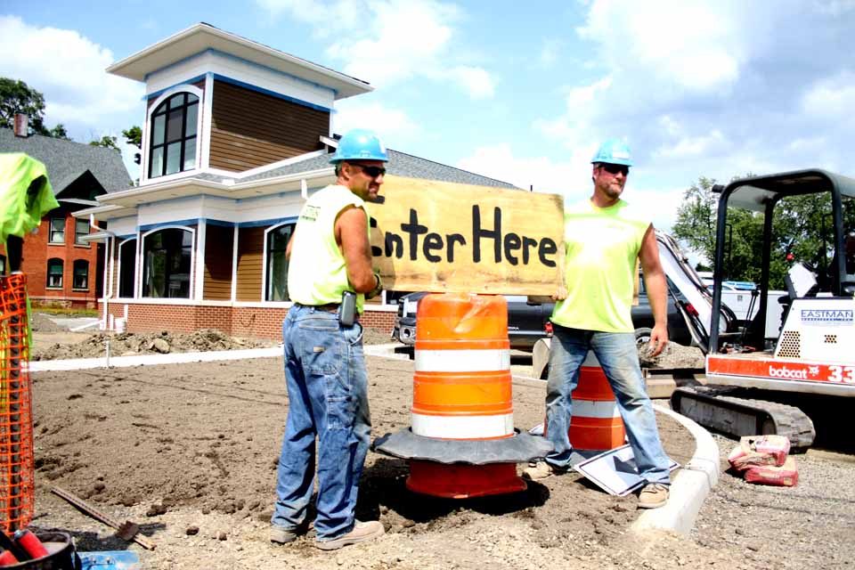 The Bank of Cooperstown's Oneonta branch is beginning to take shape on Main Street, across from the River Street intersection.  Here, Steve Conklin, left, of Laurens and Dan Finny of Davenport shift signage at the end of today's shift.  The branch -- its design is modeled after an old-train depot, reflecting Oneonta's history -- is due to open in September.  (Jim Kevlin/allotsego.com)