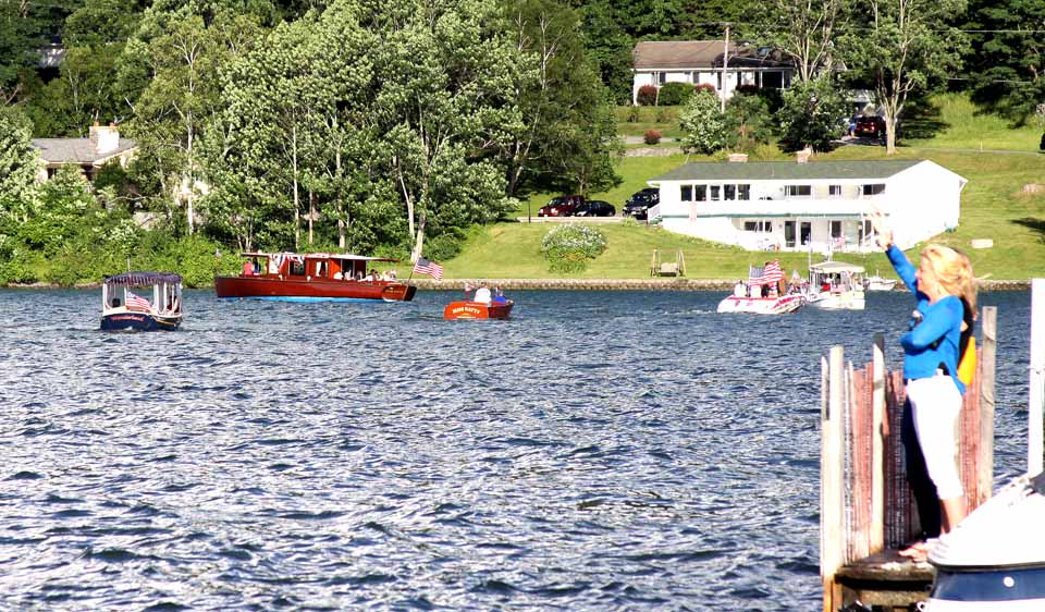 With Lou Hager's "Chief Uncas" leading, two dozen boats cruised past Cooperstown's Lakefront Park a few minutes ago, participants in the Otsego Lake Association's first Fourth of July Boat Parade.  The launches gathered off Three Mile Point, passed Kingifisher Tower and circle past the docks at Cooperstown.  (Jim Kevlin/allotsego.com)