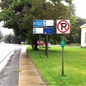 : The intersection of NY 205 and County Highway 11 in Hartwick. Town officials agree with the DOT that there is a problem with "sign clutter," but argue that a directional signs to Cooperstown and Oneonta are more important than the signs that are there.  (Alex Thomas photo)