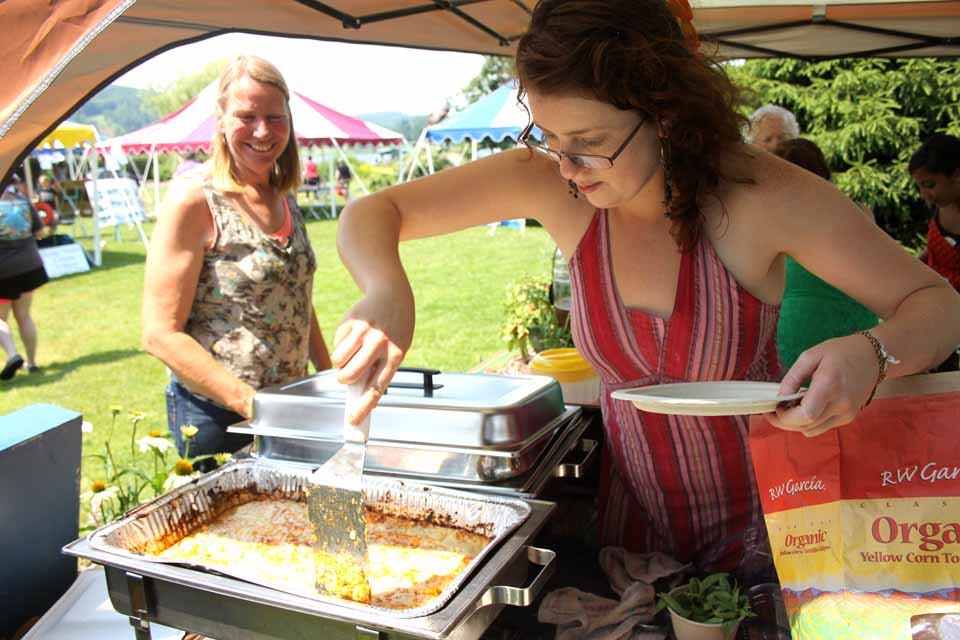 Annie Hanson, Cooperstown, serves up organic enchiladas at the Origins Cafe booth at the OCCA's Otsego Lake Festival today in Cooperstown's Lakefront Park.  (Jim Kevlin/allotsego.com)