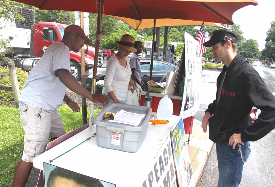 Jason Knoblauch, Oneonta, right, signs up for the Lyndon LaRouche PAC this morning at a booth set up next to the Stewart's on Route 28, Cooperstown.  Frank Mathis, left, of the LaRouch PAC, said a week-long drive is encouraging people to contact their congressmen -- Chris Gibson, R-19, is among them -- urging them to back legislation to impeach the President.   The chapter, based in New Jersey, was in town for a similar drive last October.  (Jim Kevlin/allotsego.com)