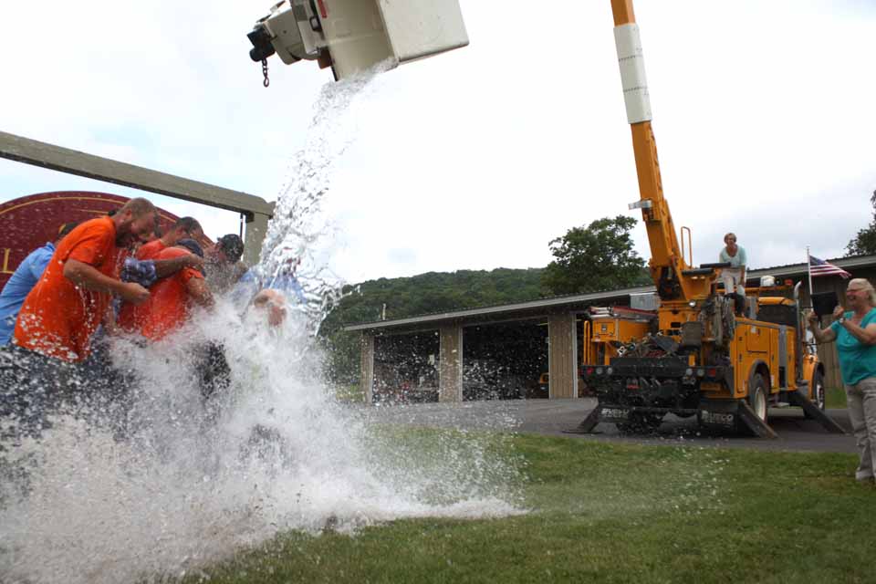 A backload bucket full of icey water is poured down on Otsego Electric Cooperative President Steve Rinell and his crew this afternoon, part of the ALS Challenge.  (Jim Kevlin/allotsego.com)