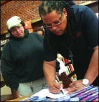 Daryl Brown, son of music legend James Brown, signs a copy of his book “My Father The Godfather” to Oneonta’s Kelly Senhouse. (Ian Austin/HOMETOWN ONEONTA)