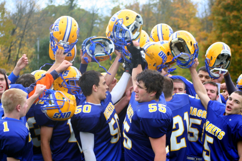 The Oneonta Yellowjackets lift their helmets in celebration at the conclusion of the homecoming game on Saturday afternoon where they defeated the Dryden Purple Lions 19 to 26.