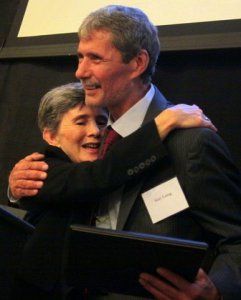 Diane Aaronson, Chairperson of the FOF Board, embraces Gary Laing after awarding him the Community Leadership award for his work and variety of programming he has brought to Damaschke Field.