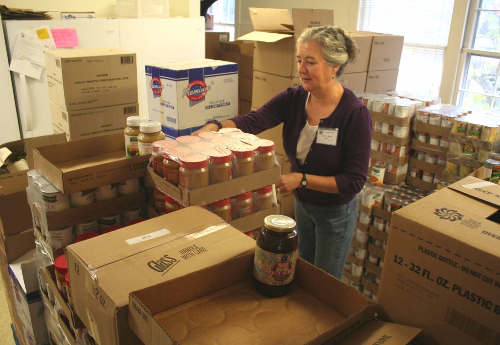 Cooperstown Food Pantry manager Audrey Murray stacks boxes of food in the new ground-level quarters at the Cooperstown Presbyterian Church offices, 25 Church St., this morning.  The renovations of the new quarters and moving inventory from the building's basement was completed yesterday.  Audrey said $5,000 was raised to match a Scriven Foundation grant, and that assisted the project's completion.  The new quarters include a waiting room for clients. (Jim Kevlin/allotsego.com)