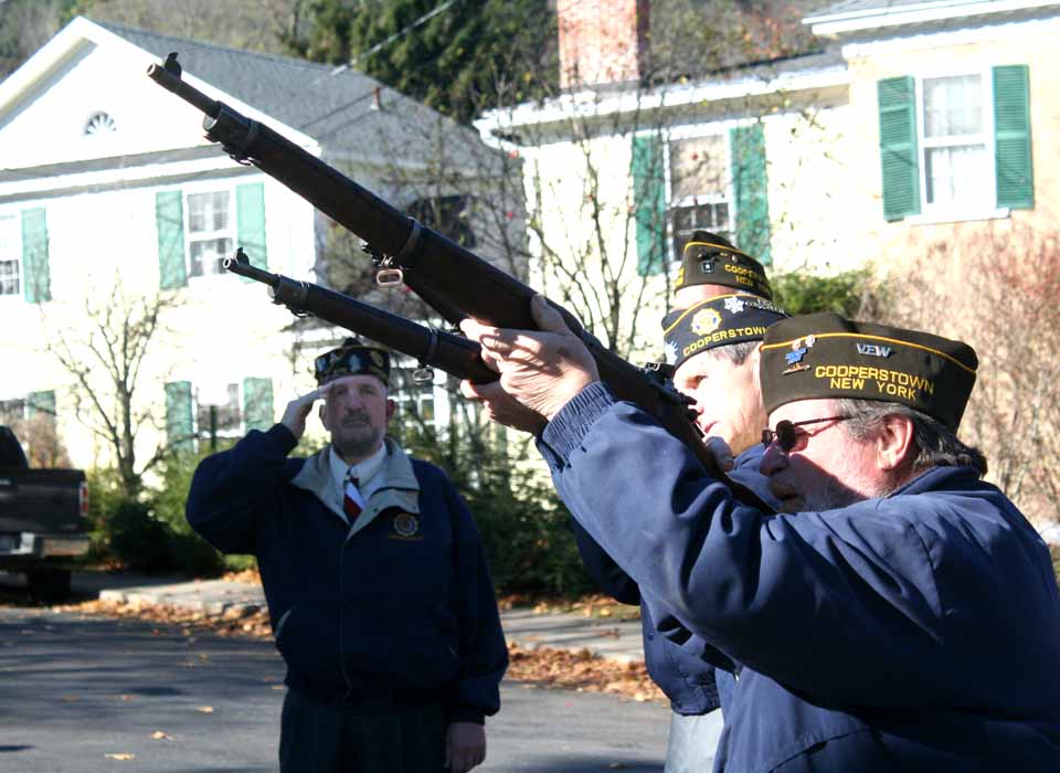 A rifle squad fires three rounds to honor the fallen at the Cooperstown Vets Club Veterans Day ceremony this morning at the Doughboy State, Pine Boulevard and Lake Street. Doing the honors are David Sanford, Rich Balcom and Jim Bridger. American Legion Command Mike Boyson is on the far side. (Jim Kevlin/allotsego.com)