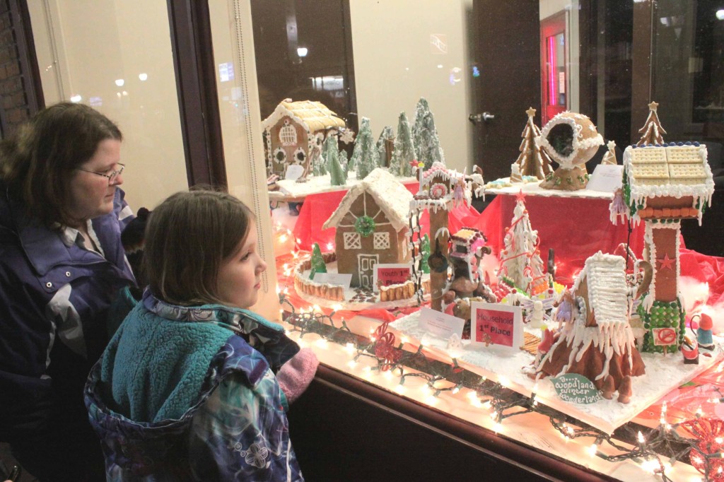 Susan Phillipe, Julian Chauncey and Jessica Phillipe, Oneonta, peer in the Key Bank window at the Winter Wonderland Gingerbread houses. 