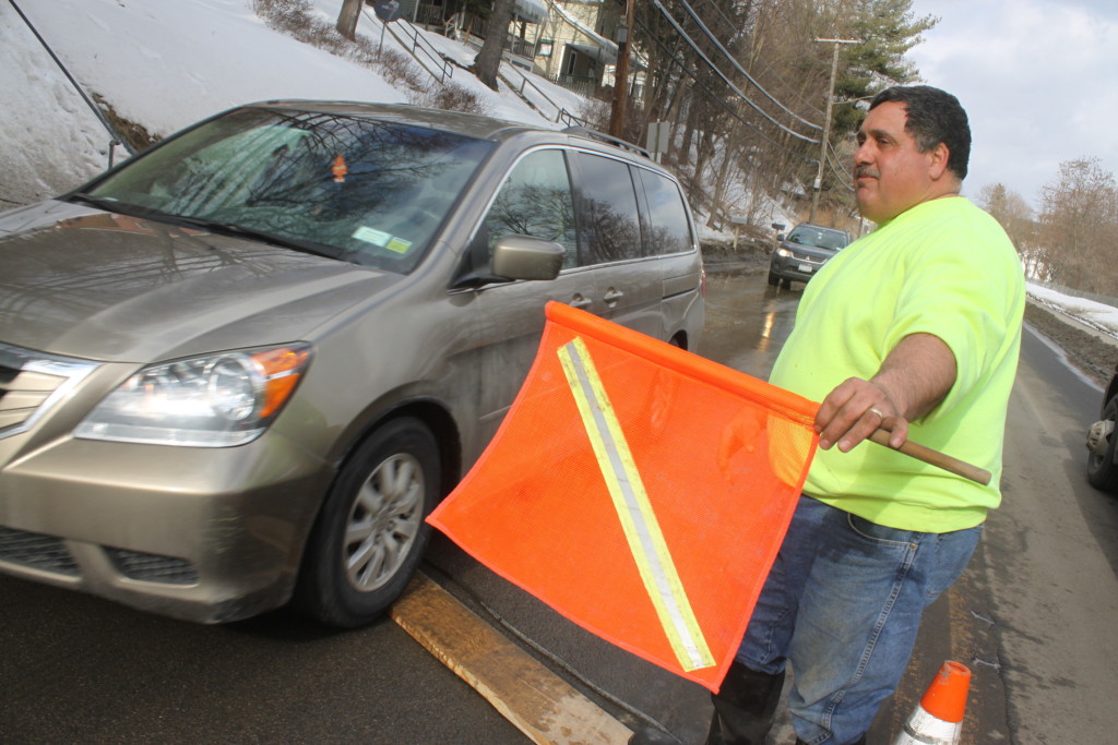 Tom Pondolfino, Oneonta, directs traffic while city contractors work at thawing frozen pipes at 145 Chestnut. The cold February has frost permeating the ground deeper than normal, causing many water main issues. "We've responded to 30 calls just this month!" said Pondofino. (Ian Austin/ allotsego.com)