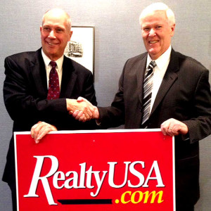 RealtyUSA's Merle Whitehead, left, and Exit's Tom Tillapaugh shake after the merger was agreed upon today.