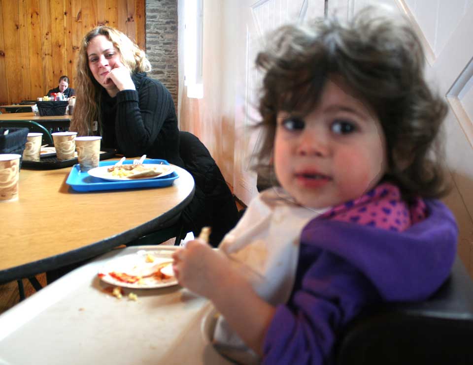 Under the watchful eye of mom Christine, Lauren Isgro, 2, tucks into her breakfast this morning at The Farmers' Museum's first Sugaring Off Sunday, a sign of spring around here. Volunteers are serving eggs, pancakes and other goodies until 1 p.m. (Jim Kevlin/allotsego.com)