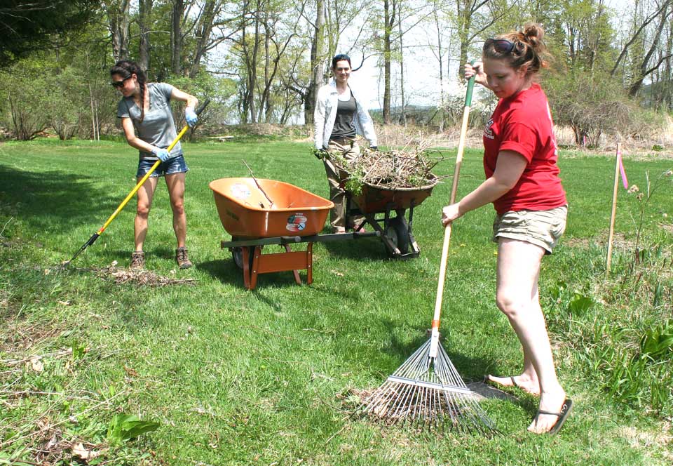 Volunteer Emma Garrison, Cooperstown, left, helps Otsego Land Trustee Outreach Coordinator Sara Scheeren, Cobleskill, right, and Stewardship Manager Marcie Foster during today's annual cleanup at Brookwood Gardens, the Land Trust property on Otsego Lake.  (Jim Kevlin/allotsego.com)