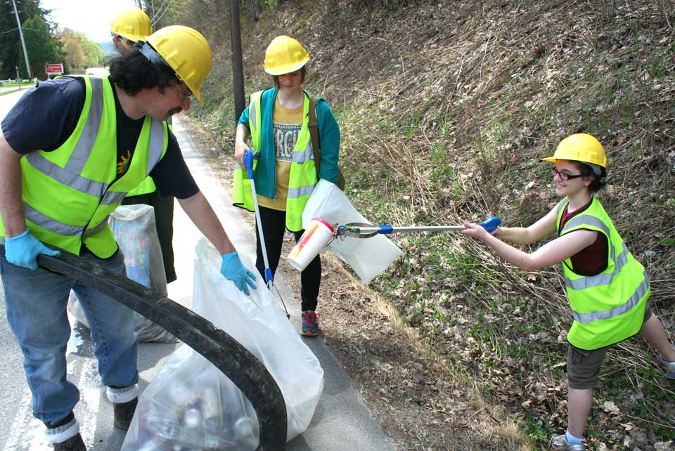 Up West Lake Road, the OCCA annual cleanup of Route 80 was underway.  At right, Gwen Calchi, Milford, snags a discarded drink container from the roadside and discards it in a trash bag toted by the OCCA's Jeff O'Handley.   Sarah Gerold, Milford, and Nora Ashwood, Roseboom, assist.