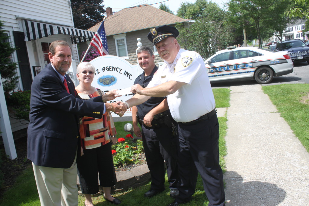 Steve Bieritz, of the Bieritz Insurance Agency of Cooperstown, hands Chief Michael Covert a check for $2,914 to Chief to purchase four Body Worn Cameras for his officers.  The cameras, which will be turned on during all arrests, calls and stops. Also pictured are Sally Bieritz and Patrolman Kevin Voce.