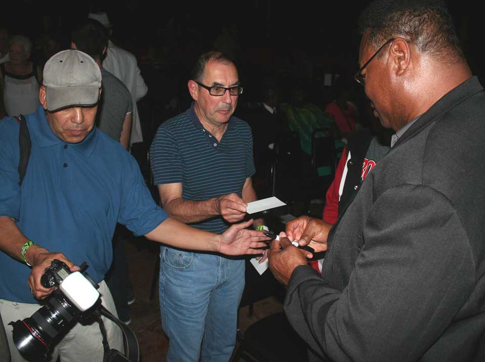Larry Holmes, former world champion heavyweight, signs an autograph for Bill Pietraface, the retired SUNY Oneonta professor, at an appearance this evening at the Oneonta Theatre to promote the audiobook for Marvis Frazier, son of a former heavyweight champion of the world. Frazier's biography, by Oneonta's Jamie Potter, was published last year; Potter is now working on Holmes autobiography. (Jim Kevlin/allotsego.com)