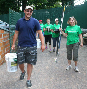 Doubleday Field manager  Quinton Hasak leads a group of Tourism Cares volunteers into the field this morning.
