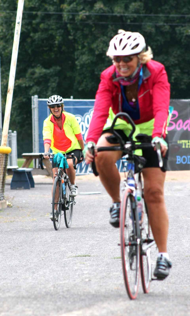 Kathleen Galland, with her pal Christine McBrearty-Hulse behind her, rides into the Damaschke Field parking lot after last September's Bike Otsego.  She was a staple in local running and biking events through her cancer fight.  (allotsego.com)