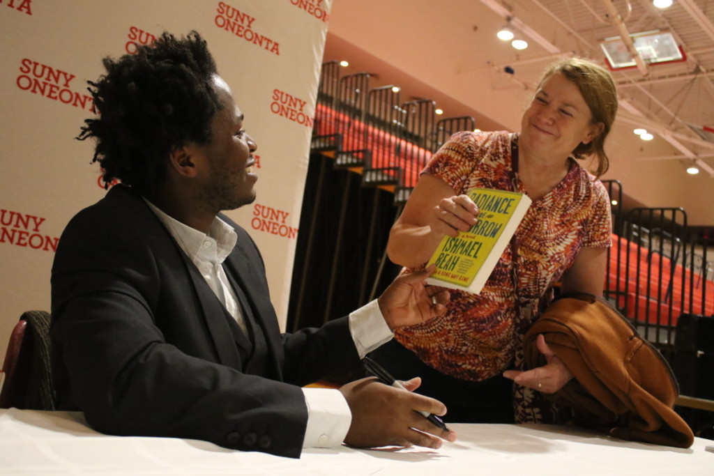 Ishmael Baeh signs a copy of his memoir "A Long Way Gone" for Susan Ryder at the end of the annual Mills Lecture, held earlier this evening at SUNY Oneonta.