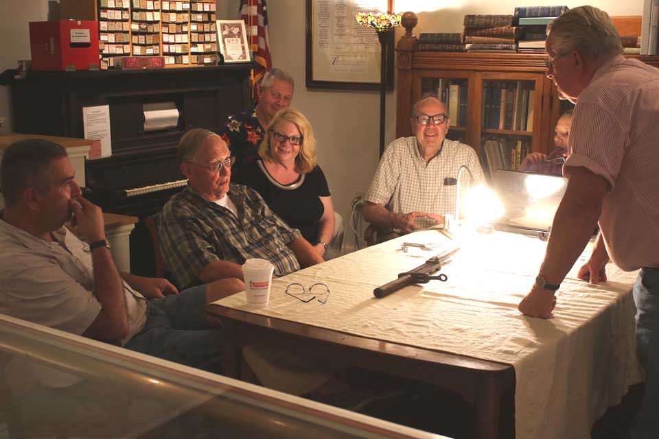 A team of experts – from left, Kevin Herrick, Lettis Auctions; Al Bullard, the hops experts and Milford collector; Lynn Price (with husband Dale behind her), extensive collectors of antique buttons; Bob Turrell, the Market on Chestnut Street, and GOHS stalwart Loraine Tyler – assess a tool provided them by Charles Bullard, Al’s brother, who is visiting from Morton, Pa., during a fundraising appraisal night at the Oneonta History Center. GOHS Executive Director Bob Brzozowski said 30-some items had been brought in by 6:30 p.m., halfway through the evening. The experts decided this tool was a “threader” that added threads to homemade screws and bolts. (Jim Kevlin/allotsego.com)