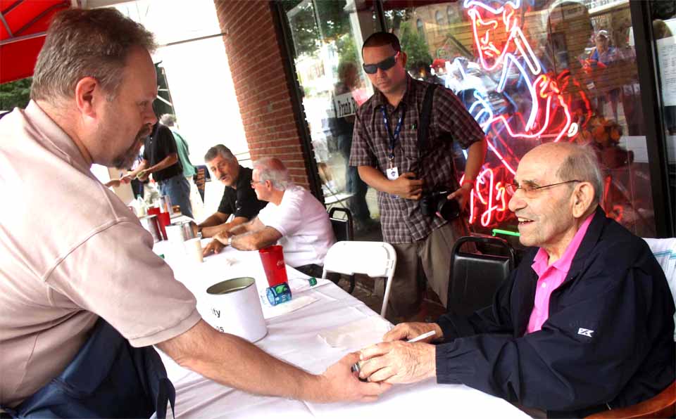 Yogi Berra was signing autographs in front of TJ's Place this afternoon as Induction Weekend got underway. Rolly Fingers is seated in the background. They were among dozens of MLB stars who will be autographing on Main Street through the weekend