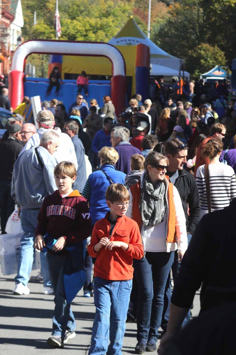 The first Cooptoberfest filled Main Street, Cooperstown, today, drawn by family-friendly fun, games and food. Walking toward the camera are the Savoie family, dad Ben, mom Jacqueline and sons Nate and Christopher. At 4 p.m., the celebration transforms into Cooperstown On Tap, a Brewery Ommegang-sponsored celebration of food and beverages. (Jim Kevlin/AllOTSEGO.com)