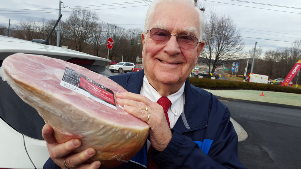 Retired Baptist minister Rev. Mel Farmer shows off one of the hams he gave away as part of his 'Angel of Love' program over the holidays. A record 150 families requested a Thanksgiving turkey and a Christmas ham, and Farmer was able to give $200 to the Friends of Christmas dinner at the First United Methodist Church. (Ian Austin/AllOtsego.com)