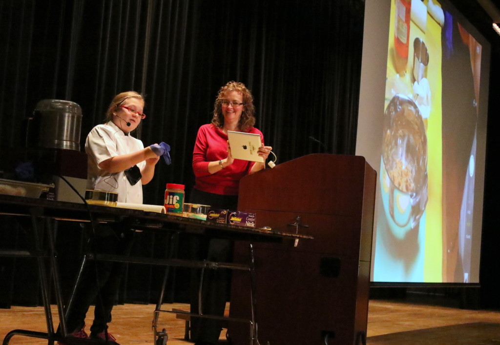 Julia Rissberger readies for her food demonstration at the OHS auditorium for the middle school, while her mother Rachel projects the proceedings on the big screen for the audience. Julia, who in was a winner of PBS’ Healthy Lunchtime Challenge in July. She was preparing an original no bake recepie she calls "Bird Food", made form peanut butter, dried fruit and seeds. Later, she was joined by Chef Jim Perillo from the Otesaga Resort Hotel who shared his carrot hummus recipe. (Ian Austin/AllOTSEGO.com