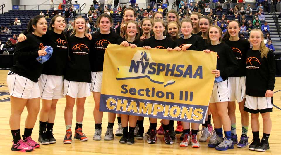 The Cooperstown Hawkeye girls pose with their Section III Class C Championship banner after defeating Syracuse Academy of Science 54-30 in the finals at Onondaga County Community College Sunday afternoon. They will next play Watkins Glen the Section IV Champion next Saturday at Colgate University in the New York State quarter-finals with the winner advancing to the Final Four at Hudson Valley Community College in Troy the following weekend. Cooperstown is the defending New YOrk State Class C Champion. (Brian Horey/AllOTSEGO.com)
