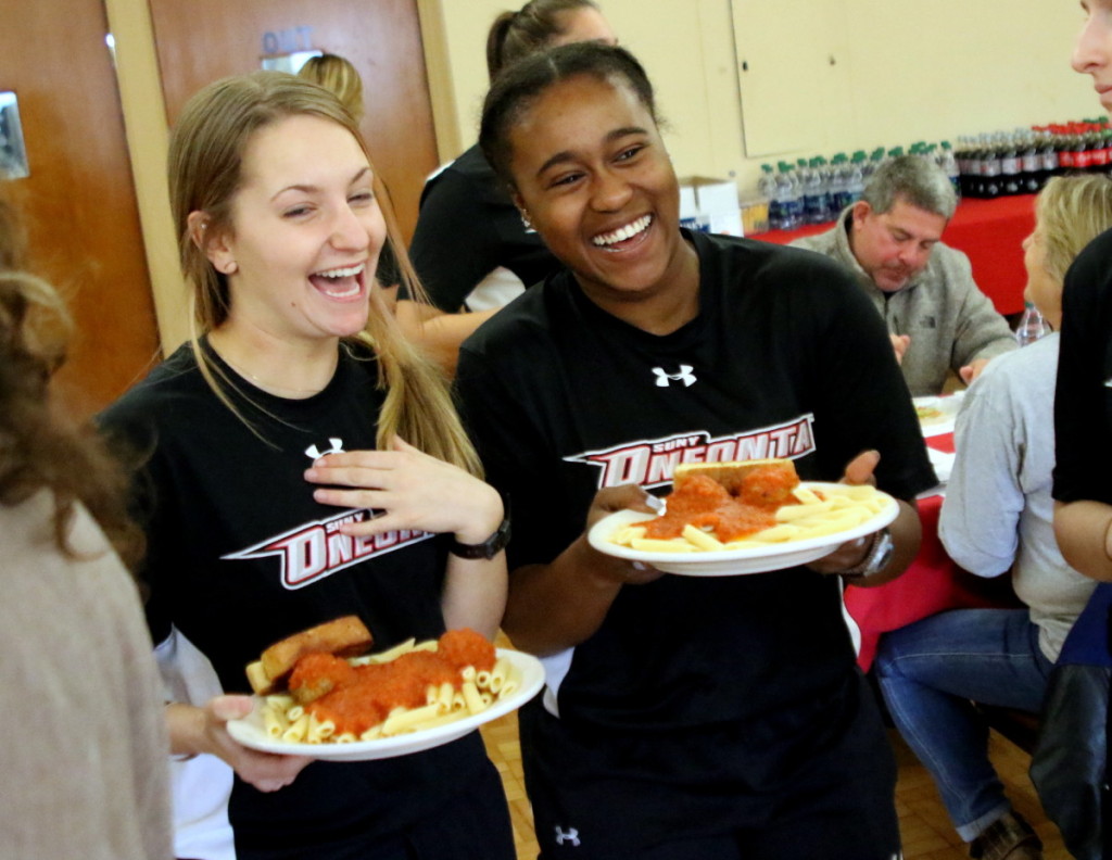 The SUNY Oneonta Women's Soccer Team sold over 400 tickets, the most ever, to their 11th annual Dinner and Auction With The Dragons at The Oneonta Elks Lodge this afternoon. In addition to the auction, dinner and dessert, attendees enjoyed conversation with the team about their past season. The proceeds from the luncheon will fund the team's upcoming training trip to Florida. Here, Seaver Lipshie and Kayla Jones-Lockridge, members of SUNY Oneonta's Women's Soccer team, bring plates of spaghetti, meatballs and garlic bread. (Ian Austin/AllOTSEGO.com)