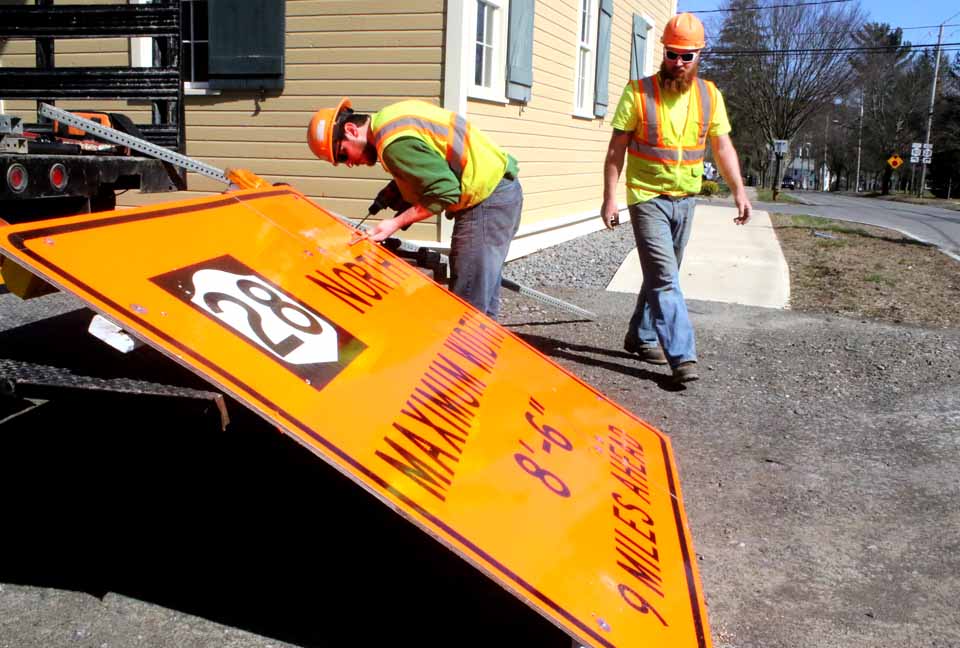 With a Route 28 bridge replacement due to begin this Monday, April 4, a team from Comet Flasher, Tully, a state DOT subcontractor, are erecting a sign at this hour at Railroad and Glen avenues, Cooperstown, warning truck drivers that vehicles wider than