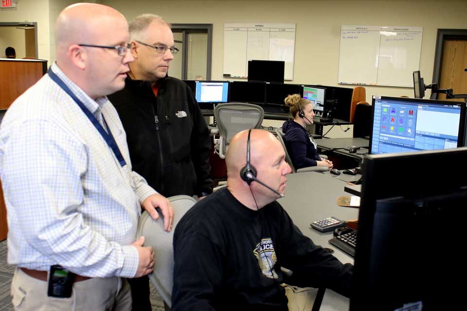 Rob O'Brien, left, Otsego County E911 Communications director, and Brian Pokorny, county Information Technologies director, observe Dispatcher John Dinneen, Rosebook, field calls as the county's new 911 emergency dispatch center went on line today in the county's Meadows Office Complex in the Town of Middlefield.  (In the background is Dispatcher Alicia Murphy, Otego).  O'Brien said Verizon began shifting the 911 lines from the former center at 8 a.m. today, followed by the seven-digit numbers.  Everything appeared to be functioning efficiently this afternoon, he said.  (Jim Kevlin/AllOTSEGO.com)