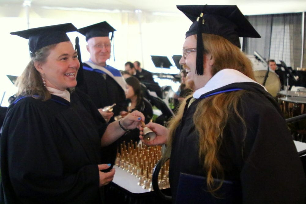 This morning marked the 85th Hartwick commencement on Oyaron Hill in Oneonta where over 350 graduates accepted their degrees in academics, and for every one there was a commemorative bell, a replica of the Hartwick bell that hangs in the bell tower of Yager Hall. Here, Michael Patrick Konze, Oneonta, left, accepts his bell from Alicia Fish, and Duncan McDonald. At the conclusion of the ceremony all graduates ring their bells to symbolize their graduation from the college. (Ian Austin/AllOTSEGO.com)