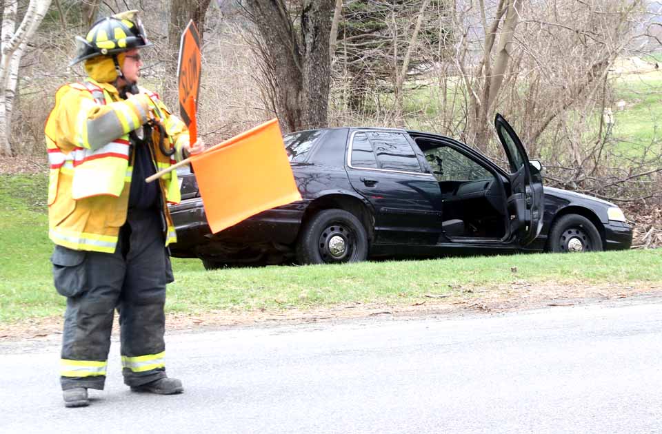 Bredin's vehicle ended up on the east site of Route 28 after Friday morning's crash. Scott Gage directs traffic. (Jim Kevlin/AllOTSEGO.com)