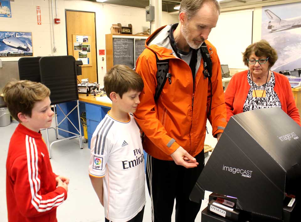 Dr. Matt Spencer brought sons Liam, 12, and Aidan, 10, to see democracy in action as he voted on CCS' proposed 2016-17 budget this evening at the high school. (Jim Kevlin/AllOTSEGO.com)
