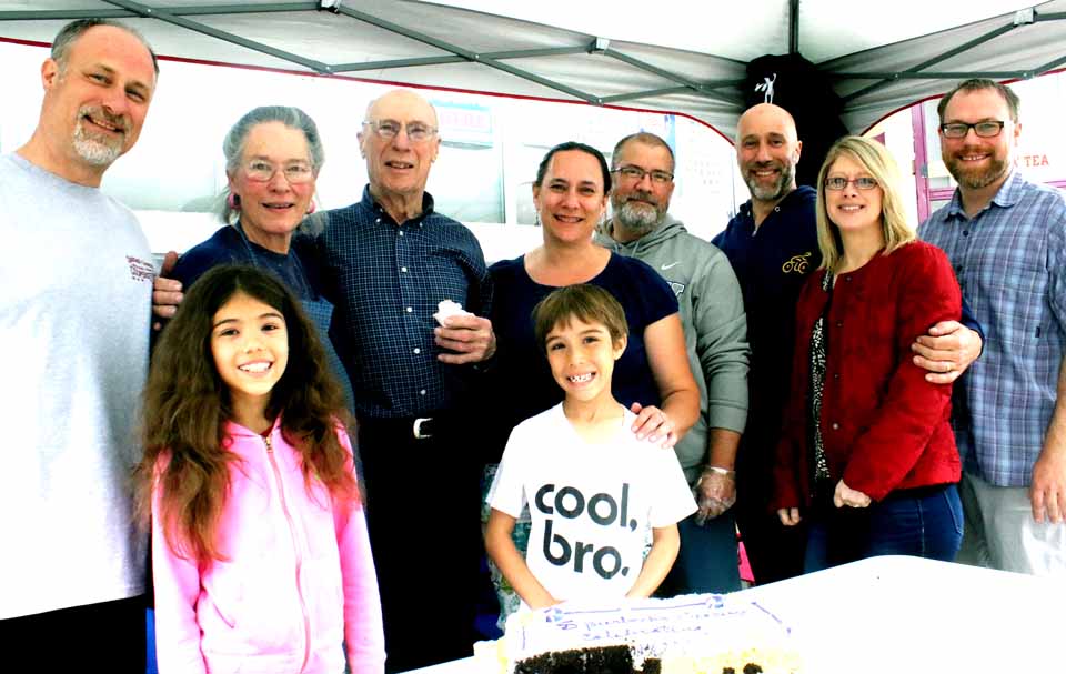 A few moments ago, the Smith family cuts the 75th birthday cake celebrating the three-quarter-century mark on Spurbeck's Grocery, Railroad and Leatherstocking, in Cooperstown. Proprietors Dorothy and Roger Spurbeck are third and fourth from left. Their children, from left, are Randy Smith, Cooperstown, daughter Laura Flint of Jay with her husband, Robin, Steve Smith, the local contractor, and his wife Sheri, and Marty Smith of Boston. Marty’s children, Amiya, 10, and Rowan, 8, are in the foreground. The store was founded by Roger Smith’s grandfather, Orlando Spurbeck, and then operated by his mother, Gertrude Spurbeck Smith. While a full service grocery, Spurbeck’s is particulary frequented for its lunchtime sandwiches and soups, its Palatine Cheese, cut from the roll, and 170 craft beers. (Jim Kevlin/AllOTSEGO.com)