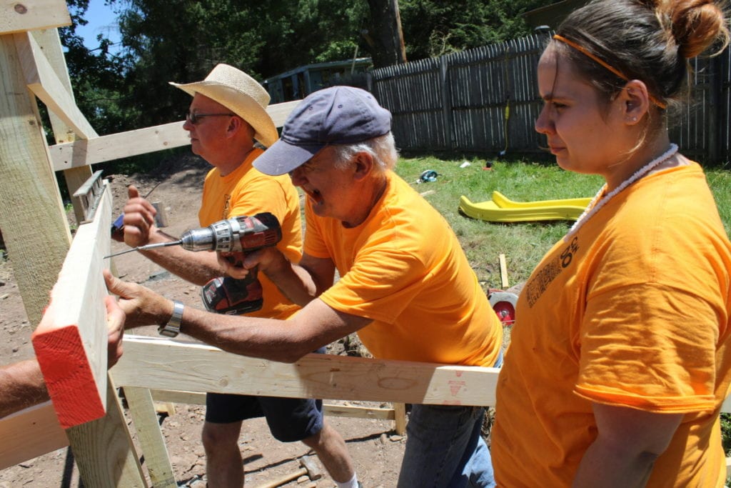 Dallas Gedney, Chip Scheiner, Casandra Decker and other members of the Baptist Church are constructing a children's playground at Lantern Hill in Oneonta as part of their first Community Outreach Project. 34 volunteers from the church are helping paint fire hydrants, build retaining walls and other projects throughout Oneonta over the weekend. (Ian Austin/AllOTSEGO.com)
