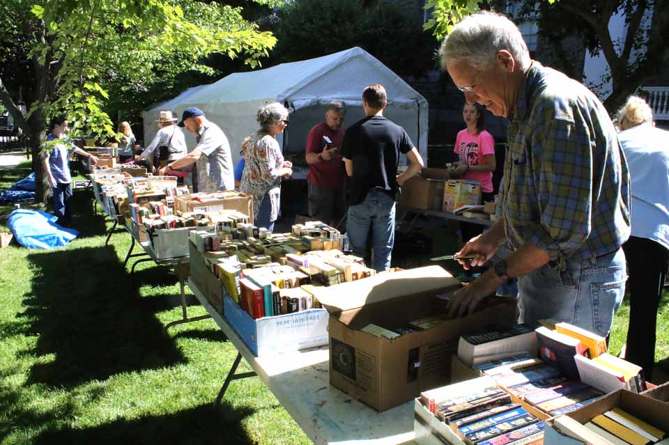 Cooperstown's Lang Keith is among volunteers unpacking books this morning for the annual Friends of the Village Library book-sale fundraiser. This year, there will be no "early bird" feature, according to sale organizer Karen Katz; the sale begins at 10 a.m. tomorrow for everybody. The sale runs daily through Monday, July 4. (Jim Kevlin/AllOTSEGO.com)