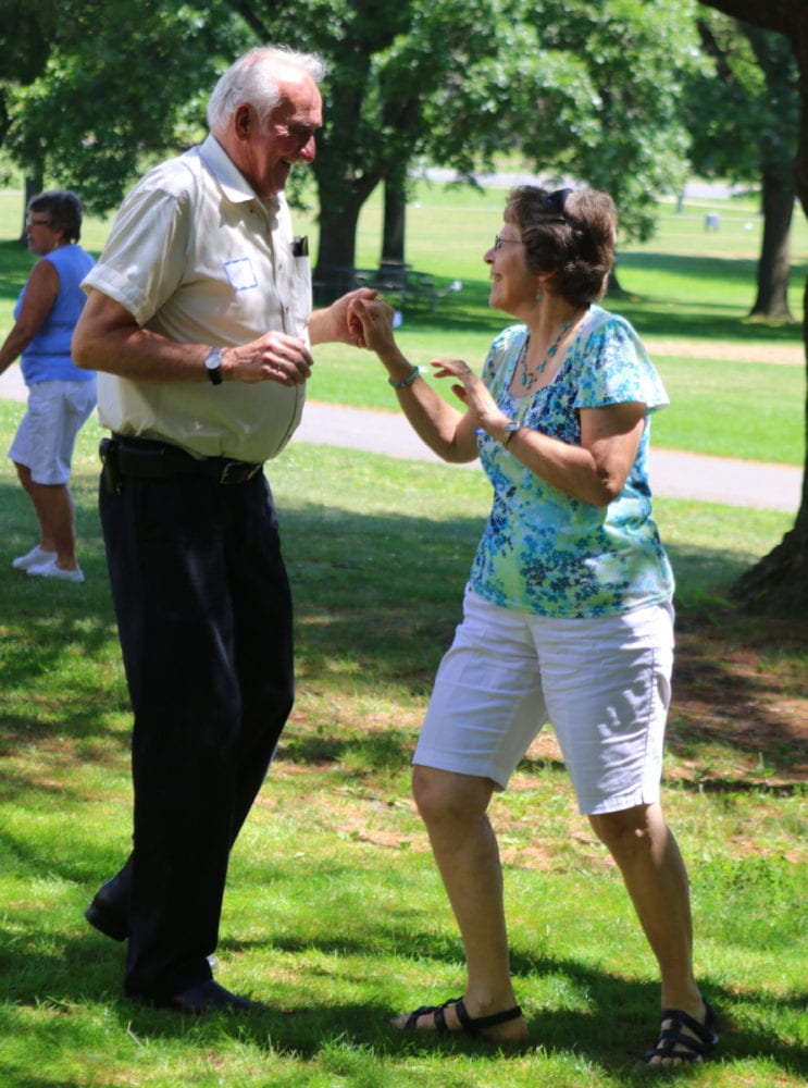 Carolyn Elwell and Art Henry, both of Goodyear Lake, dance together as Jim Dorn sings "Wagon Wheel" by Bob Dylan at the Senior Picnic at Glimmerglass State Park this afternoon. The event featured information sessions on opportunities for seniors, music, lunch, raffles and bingo. (Ian Austin/AllOTSEGO.com)