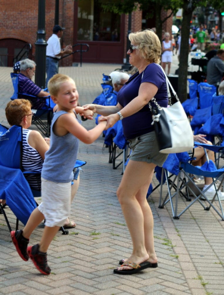 Kim Snyder, Oneonta, and her son Nathan, dance to the classic rock sounds of Off The Record, who was preforming in Muller Plaza during the Cruise In at this evening's First Friday. Main st. was closed off and filled with classic cars and food, including brownie sundaes at the Greater Oneonta Historical Society. (Ian Ausin/AllOTSEGO.com