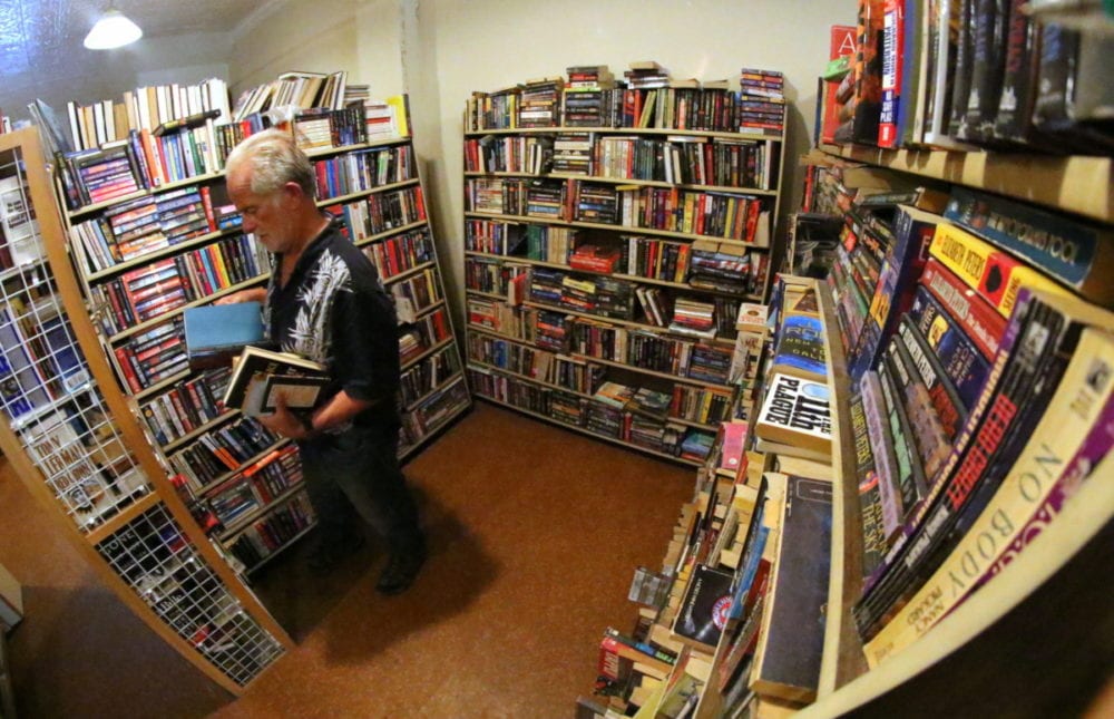 Larry Hoffman browses through the shelves of books at The Rose and Laurel Bookstore, where all the books are free for the taking. For 40 years Rose and Laurel has been a staple storefront in downtown Oneonta, but today they are closing their doors at their location at 273 Main St. Joe Mish, who currently runs the store, is moving down the street into the Shops at Ford and Main where he will continue to sell books. The space is smaller, so all the books he can't take he is giving away. Book lovers can find titles from all genres and titles from the 1800's to current. So, stop in and stock up on next summer's beach reads. The free book event goes until 2pm today. (Ian Austin/AllOTSEGO.com)
