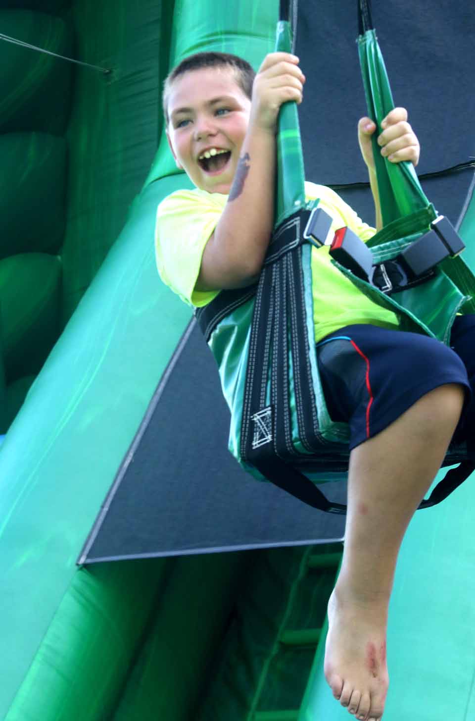 Wyatt Drake 8, of Hartwick lets out a whoop as he slides down the Amazon Zip Line, one of the carnival rides offered today and Sunday at the Hartwick Field Days.  The parade is at 6 p.m. -- you can still make it if you hurry.  Fireworks are at dusk, and the Jason Wicks Band plays to 11.  (Jim Kevlin/AllOTSEGO.com)