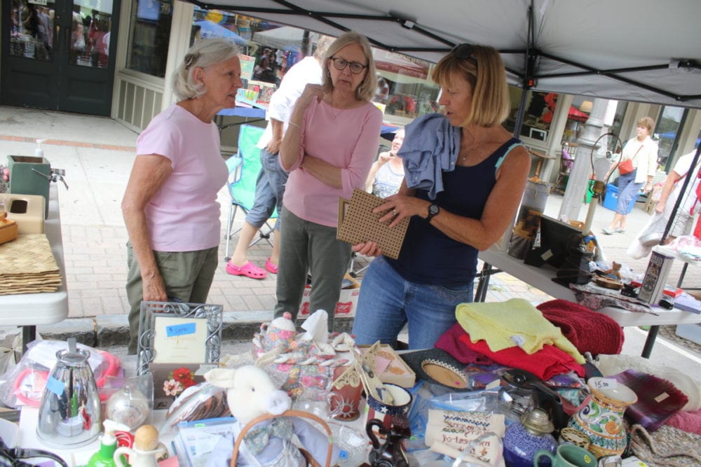 Bobbi Frazier, Michele Townsend and Roxanne Murry look over the goods at the P.E.O booth at the Grand and Glorious Garage sale this morning. The event, now in it's 37th year, is organized by the Catskill Choral Society. It was bargains galore as shoppers flooded Main Street in search of treasures. Mayor Gary Herzig made the rounds with Senate hopeful Zephyr Teachout who introduced herself to vendors and shoppers. The Community Concert Band gave a performance around mid day, and there was no shortage of foo selections with everything from spicy sausages, walking tacos and local produce from the Farmer's Market. (Ian Austin/AllOTSEGO.com)