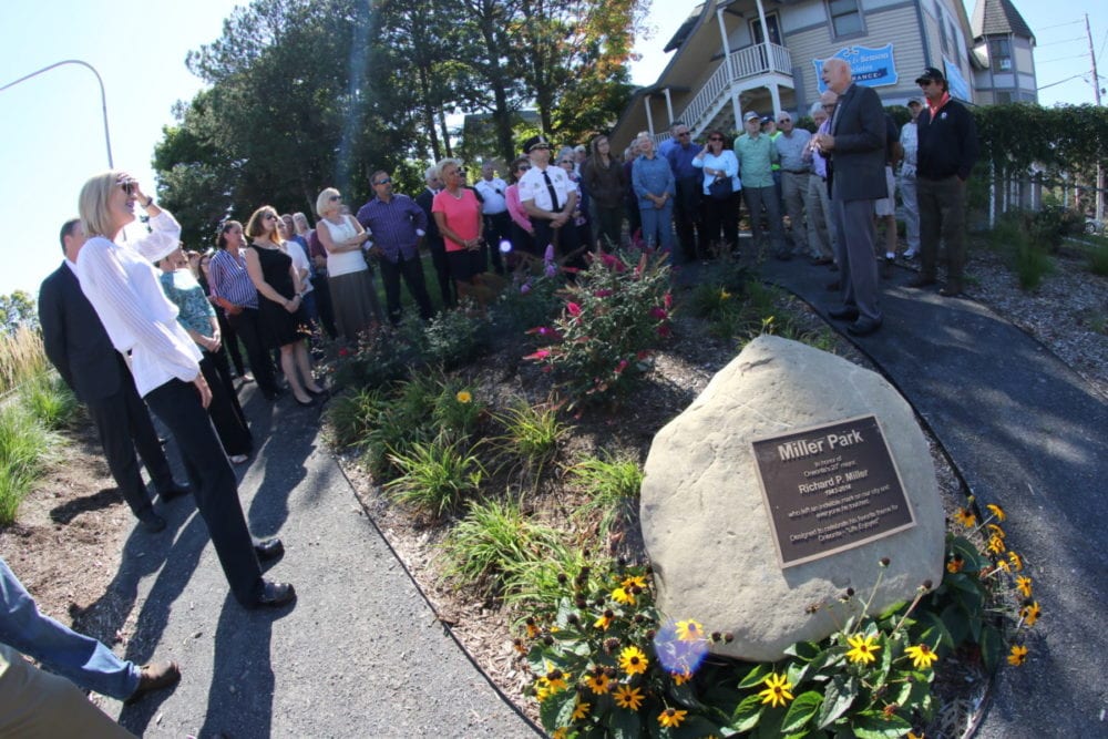 Mayor Gary Herzig, right, Andi Miller, left and scores of family, friends, and co-workers amassed at the corner of Main St. and the James F. Lettis Highway to honor the late Richard P. Miller with the official opening of Miller Park. After a few words of thanks from Mayor Gary Herzig, Miller's widow Andi thanked the crowd. "This is a great legacy for him. He was always everywhere, so having this park here, in the middle of everything is very fitting. For him, beautifying this city was not a cause, it was a passion. I think he would be really happy with it." The park was the brain-child of Al Cleinman and Richard Miller, who both believed strongly in beautifying entrances to the city. "We all have responsibilities to invest in the world around us." said Cleinman, "I could not have done this without the members of my team. Thank you to you all." A sculpture garden planned for the park and Cleinman is already forming plans to expand it father down the highway and to beautify the other side of the road as well. (Ian Austin/AllOTSEGO.com)