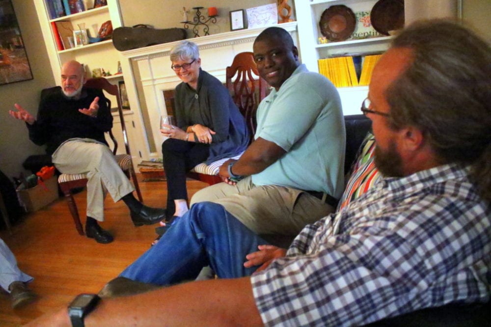 Ed Lentz, Oneonta, right, and Paul and Sarah Patterson, Oneonta, left, talk about the issues with Jermaine Bagnall-Graham, center, Sherburne, at a meet and greet hosted at the home of Daniel Butterman, a OCDC committee member. About a dozen people attended to discuss topics ranging from renewable energies, cell and internet services, taxes and keeping local businesses.  Bagnall-Graham is only the 4th candidate to run against Sen. Jim Seward, R-Milford, in his 30 year term. "I want to do what is best for the residents." said Bagnall-Graham. "I want to debate (Seward) on the issues, but so far he has not responded to me." (Ian Austin/AllOTSEGO.com)