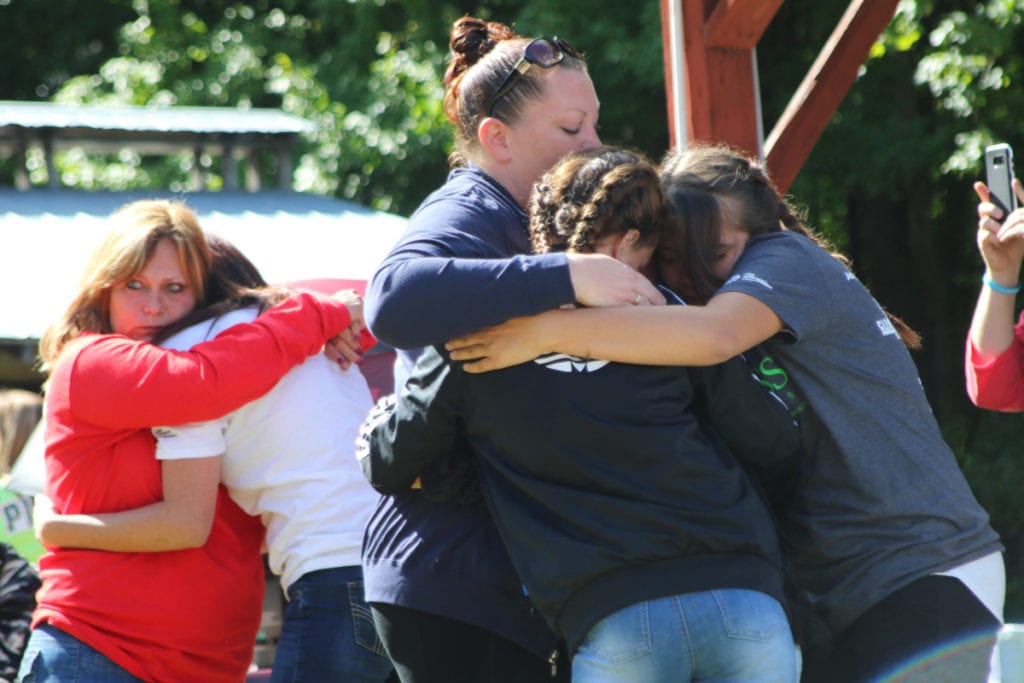 Aubrianna Robinson, Emily Runblad and Deli Lang, front, and event ornagize Donna Lang and Lyla Banhart embrace during a moment of remembrance at the 5th Out Of The Darkness Community Walk at the Moose Lodge in Oneonta on Saturday morning. Friends and families who had lost someone to suicide gathered to show support and to release the stigma surrounding suicide. The names of those lost were read aloud and balloons and pigeons were released before the walk began. The event is part of the American Foundation for Suicide Prevention. More info at afsp.org. (Ian Austin/ALLOTSEGO.com)